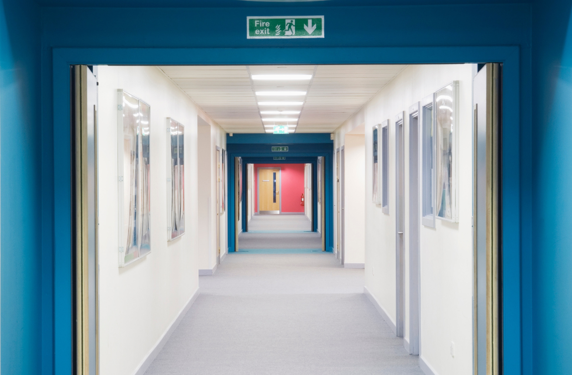 Hallway with fire exit sign above the door