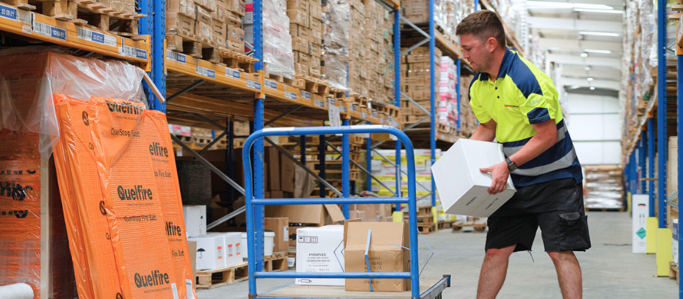 Man in a warehouse moving boxes onto a trolley