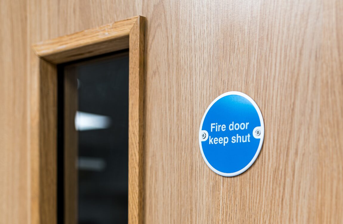 Fire door keep shut sign on timber fire door