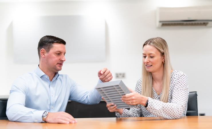 Colleagues discussing air transfer grilles